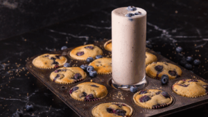 Side-by-side comparison of a blueberry muffin and IsaLean Plant-Based Blueberry Muffin Protein Shake highlighting nutrition differences.