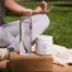 Woman doing yoga in the grass with water and Creatine.