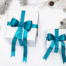 White gifts with blue ribbons on snow.