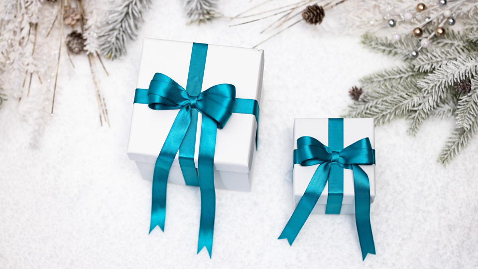 White gifts with blue ribbons on snow.